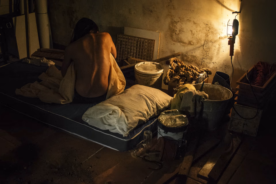 Woman with deformed back, in a basement with dim light, conceptual digital photography, 'Linji Sfużi' - a collection of short stories and photography